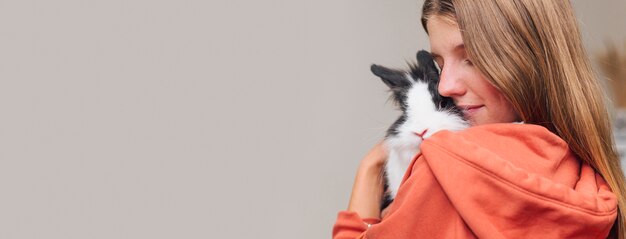 Woman petting adorable rabbit