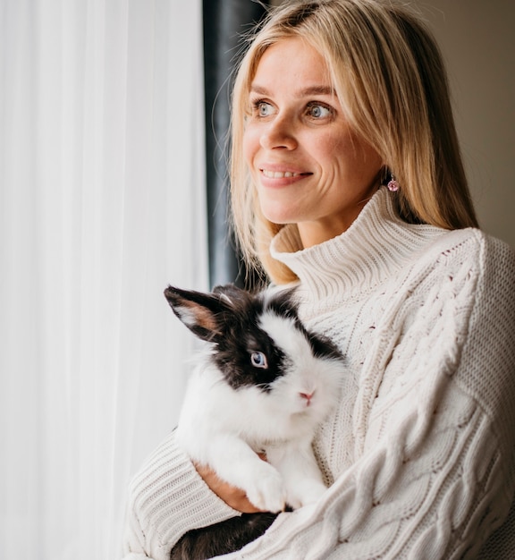 Free photo woman petting adorable rabbit