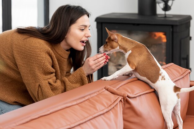 リビングルームで彼女の犬をかわいがる女性