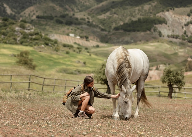 Woman petting horse full shot