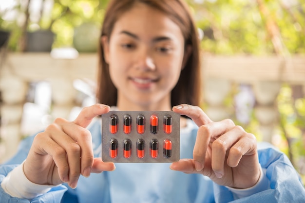 Woman pharmacist holding prescription medicine from doctor order