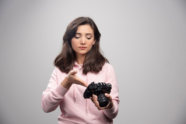 Woman photographer looking at photos on camera. 