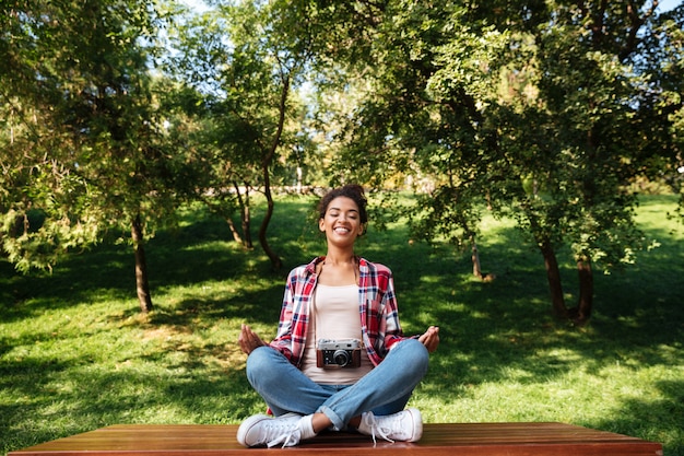 Woman photographer sitting outdoors in park meditate