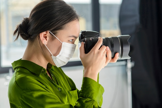 Free photo woman photographer wearing mask