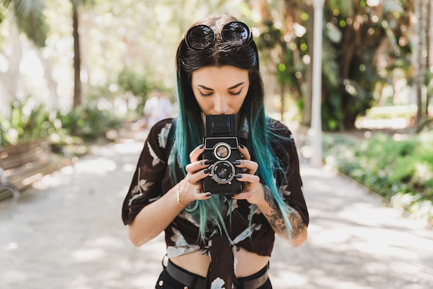 Woman photographing with twin lens reflex old photo camera