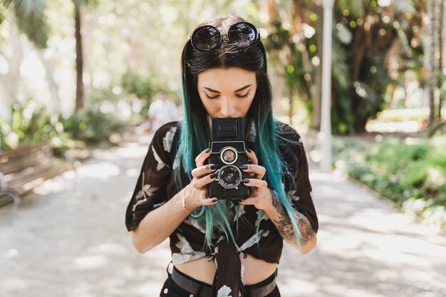Женщина фотографирует с помощью фотокамеры с двойной линзой