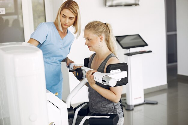 Woman at physiotherapy making physical exercises with qualified therapist