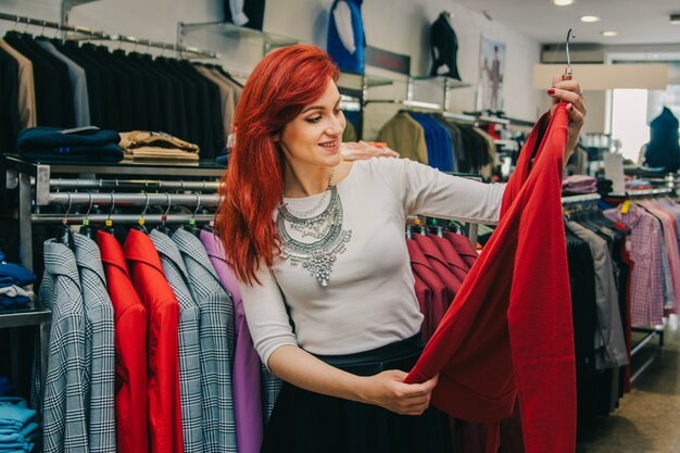 Женщина собирает одежду в бутике