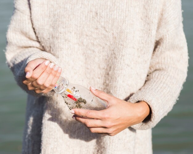 woman picking plastic from seaside