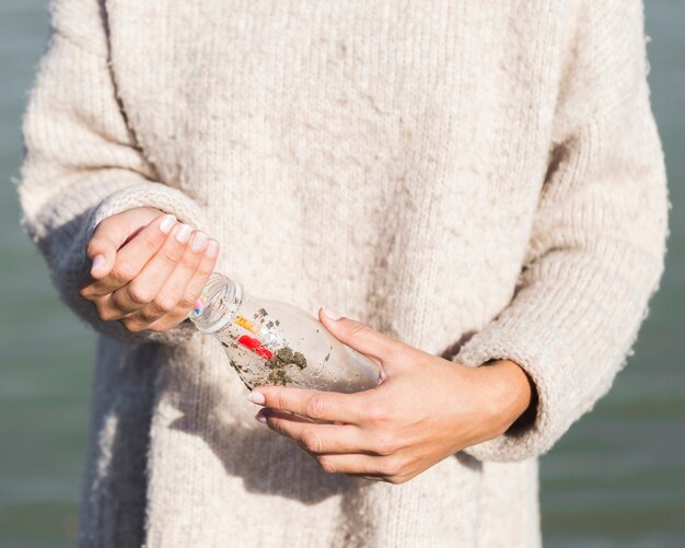 Woman picking plastic from seaside