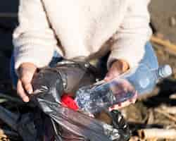 Free photo woman picking trash from seaside