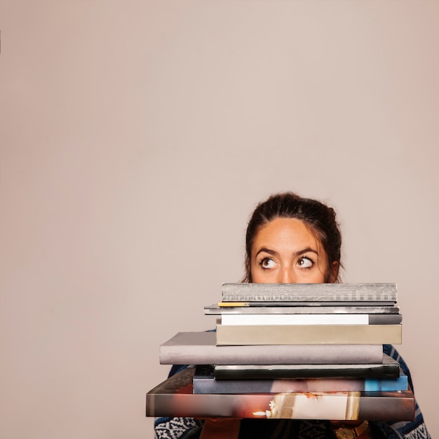 Woman behind pile of books