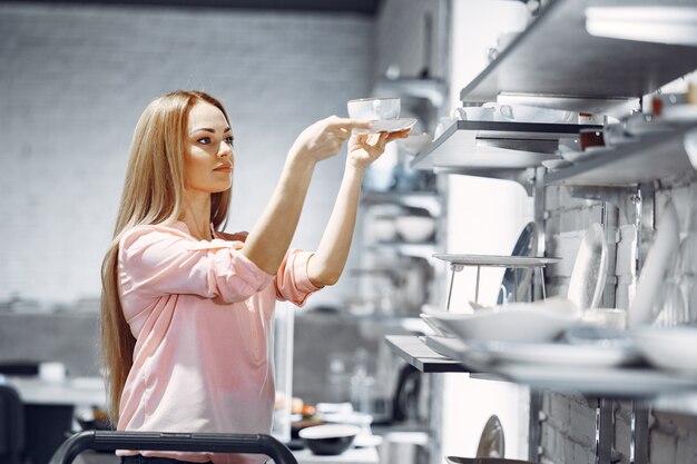 Free photo woman in a pink blouse buys dishes in the store