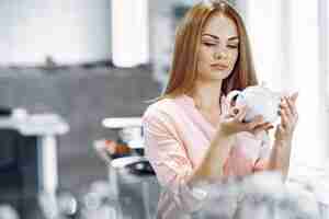 Free photo woman in a pink blouse buys dishes in the store