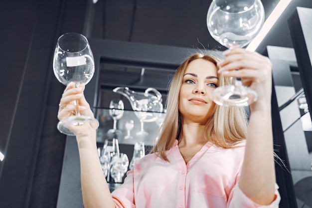 Woman in a pink blouse buys dishes in the store