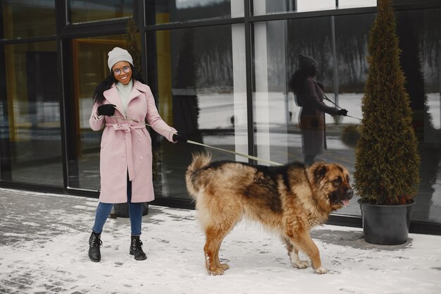 犬とピンクのコートを着た女性