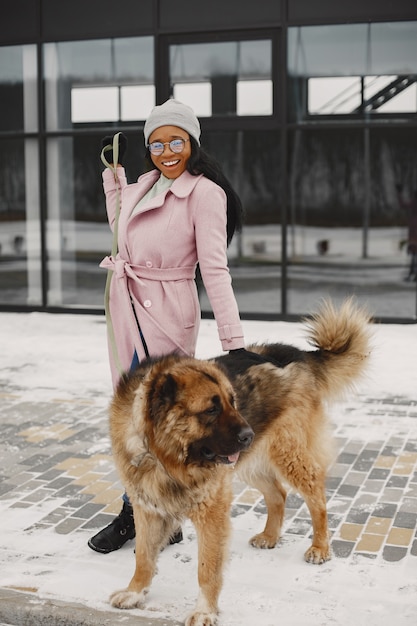 犬とピンクのコートを着た女性