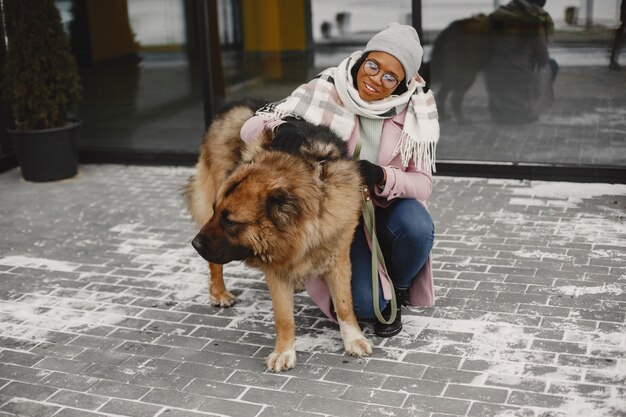 Женщина в розовом пальто с собаками