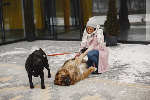 Женщина в розовом пальто с собаками