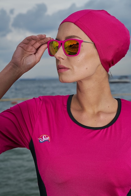 Free photo woman in pink dress and pink headscarf and sunglasses