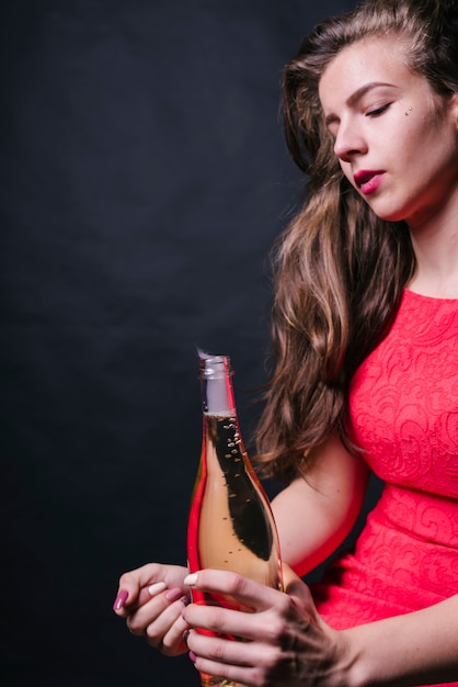 Free photo woman in pink sitting with open bottle