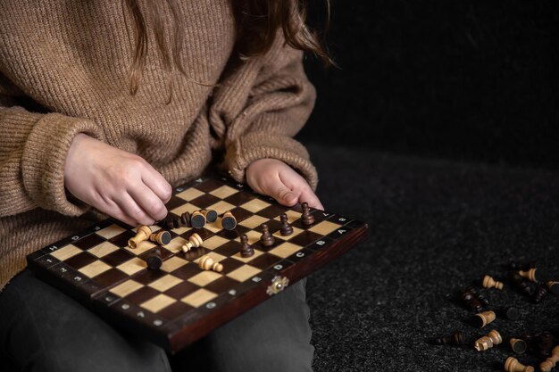 Woman placing chess pieces on a chessboard copy space