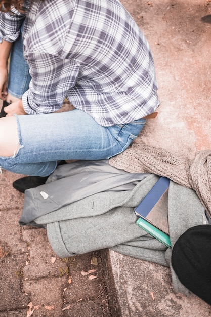 Woman in plaid shirt sitting on stone stair