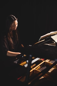 음악 스튜디오에서 피아노를 연주하는 여자