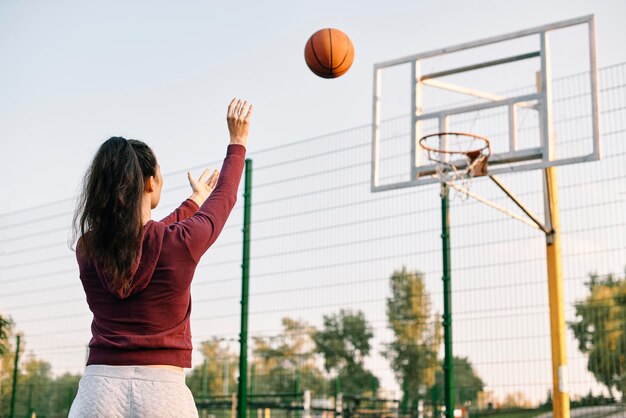 Woman playing basketball alone with copy space