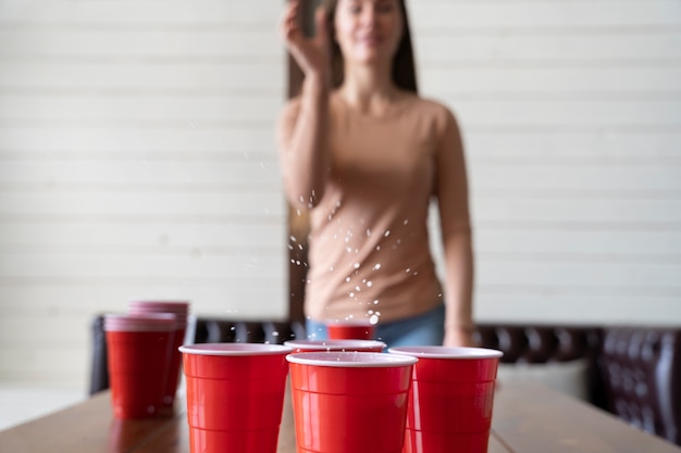 Donna che gioca a beer pong a una festa al coperto