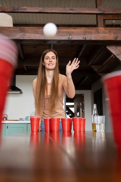 Free photo woman playing beer pong at an indoor party