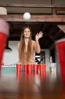 Foto gratuita donna che gioca a beer pong a una festa al coperto