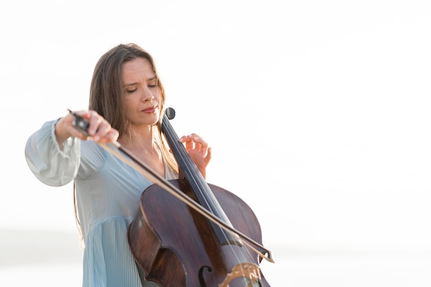 Foto gratuita donna che suona il violoncello con copia spazio