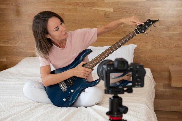 Woman playing an electric guitar at home