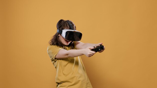 Woman playing game using vr goggles and console controller trying to win difficult level in studio. Gamer girl having intense experience with virtual reality looking at 3D surrounding enviroment.