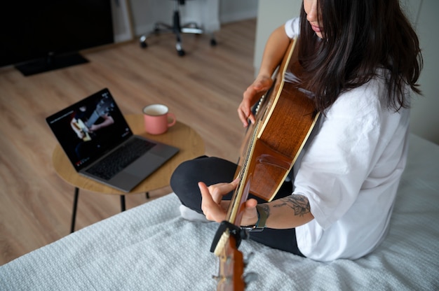 격리 기간 동안 집에서 기타를 치는 여성