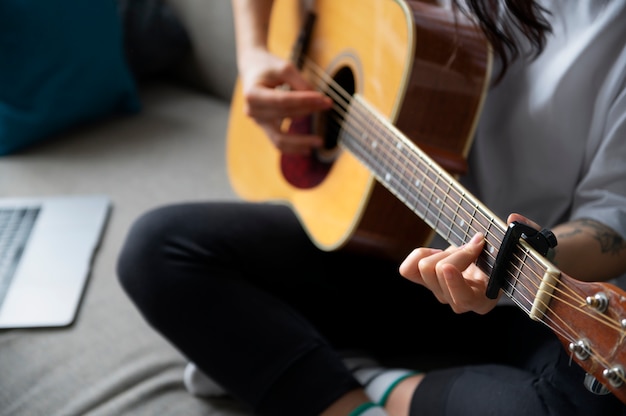 격리 기간 동안 집에서 기타를 치는 여성