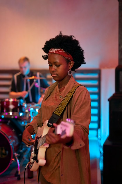 Foto gratuita donna che suona la chitarra a un evento locale