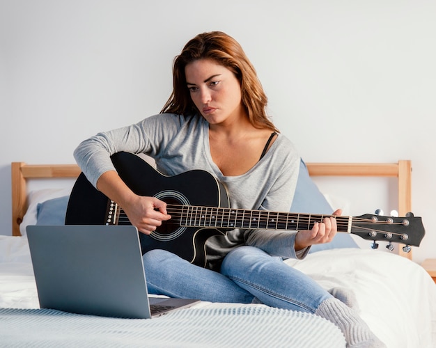 ストリーミングのためにギターを弾く女性