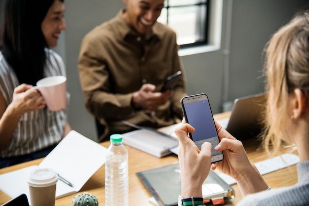 Foto gratuita donna che gioca nel suo telefono in una riunione