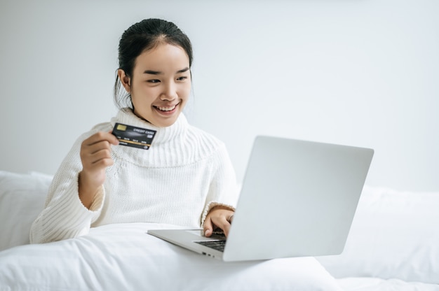 Woman playing laptop and hold a credit card.