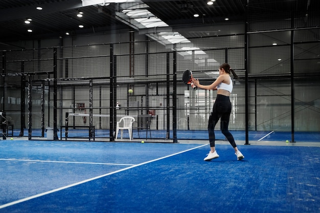 Free photo woman playing paddle tennis full shot