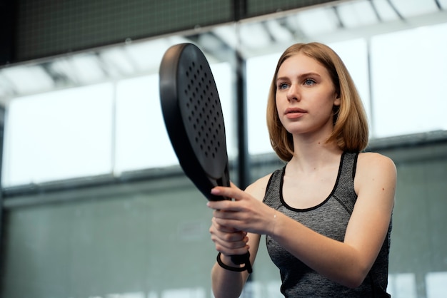 Foto gratuita donna che gioca a paddle tennis colpo medio