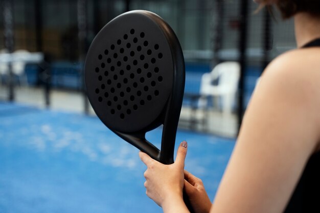 Woman playing paddle tennis side view