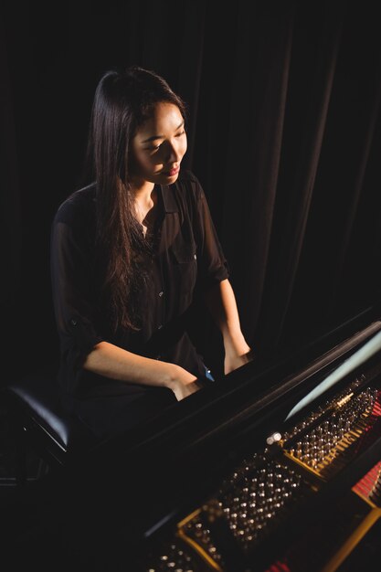 Woman playing a piano in music studio