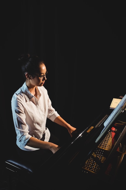 Woman playing a piano in music studio