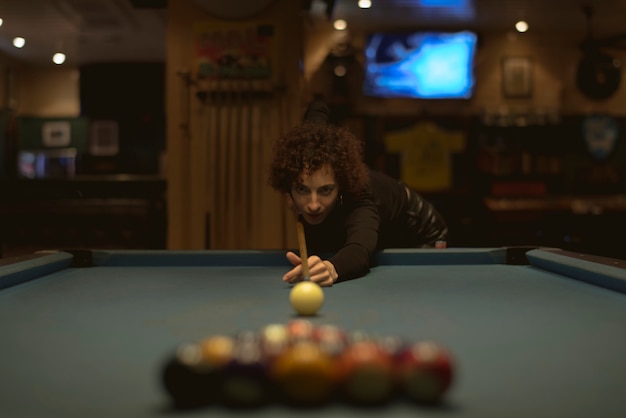 Woman playing pool at a bar