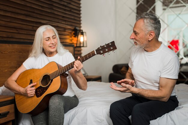 Woman playing quitar at home