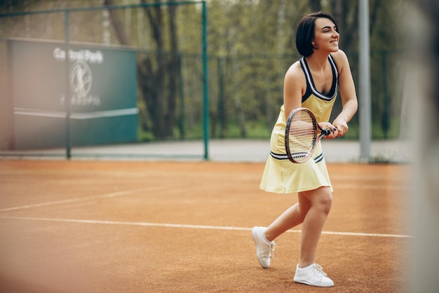 Женщина играет в теннис на корте
