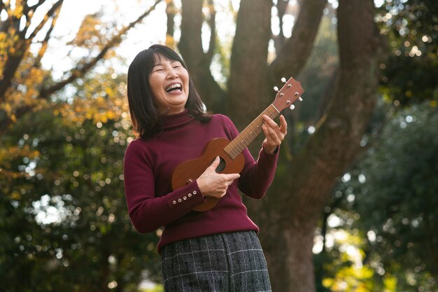 Woman playing the ukulele medium shot